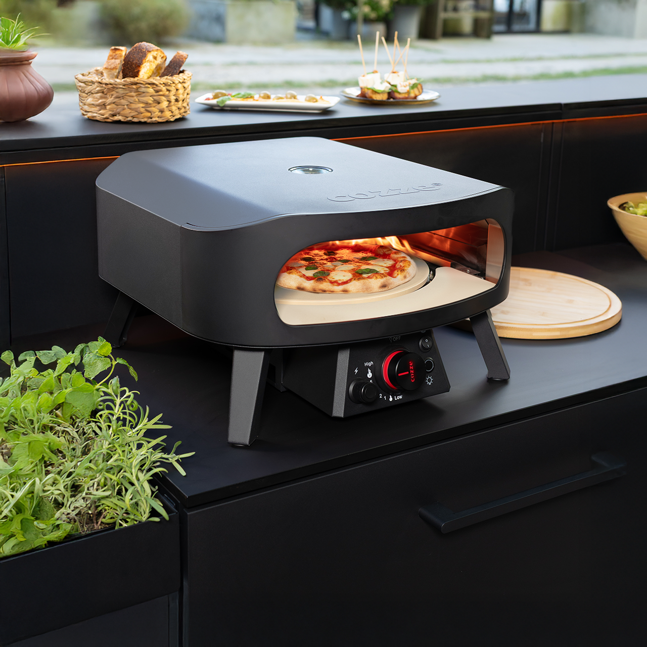Four à pizza Cozze en cuisson sur une terrasse pendant une soirée pizza