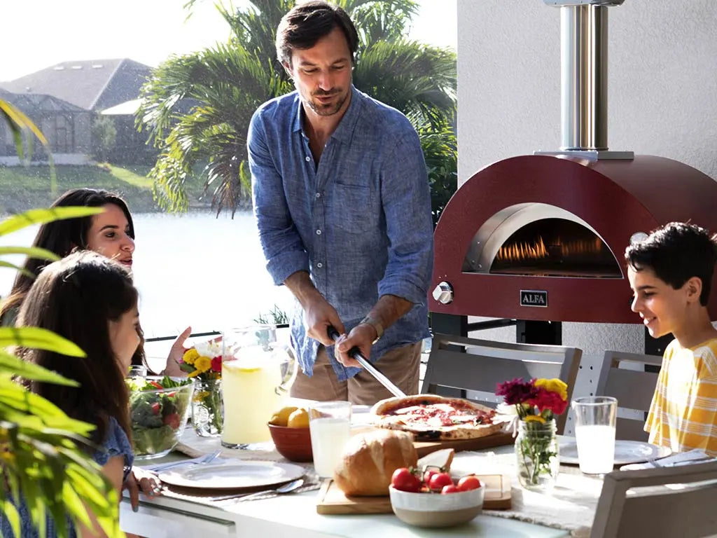 Famille réunie autour d'un four Alfa Moderno en cuisine extérieure